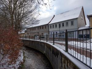 a bridge over a river next to a building at Apartment Eliese by Interhome in Suhl