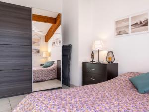 ein Schlafzimmer mit einem Bett und einem Spiegel in der Unterkunft Studio Camijeanne by Interhome in Capbreton + 15 Fotos
