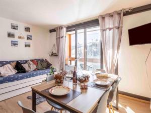a living room with a table and a couch at Studio Vostok Zodiaque-91 by Interhome in Le Corbier