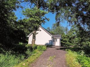 a white chapel with a dirt road in front at Holiday Home Silver Birch by Interhome in Drumnadrochit
