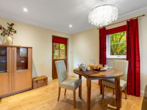 a dining room with a table and chairs and a chandelier at Holiday Home Silver Birch by Interhome in Drumnadrochit