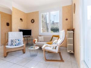 ein Wohnzimmer mit zwei Stühlen und einer Couch in der Unterkunft Holiday Home Les Albatros by Interhome in Pornic + 22 Fotos