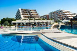 a swimming pool with a building in the background at Savoy Beach Hotel & Thermal Spa in Bibione