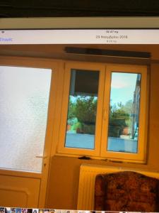 two windows in a room with a couch in front of them at Holidays Pelion studio in Nea Anchialos