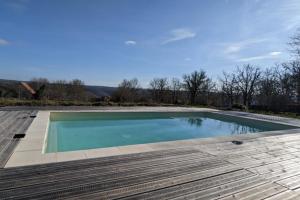 a swimming pool on top of a wooden deck at LE PARDÈS BnB jardin et piscine in Rocamadour