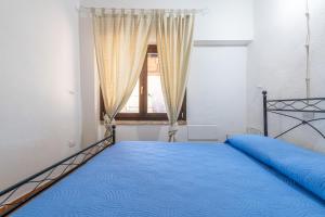 una camera con un letto blu e una finestra di Villa Bella Solanas - Cuili Murvoni a Solanas