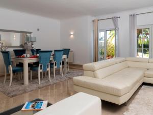 a living room with a white couch and a table and chairs at Holiday Home Girassol by Interhome in Cascais