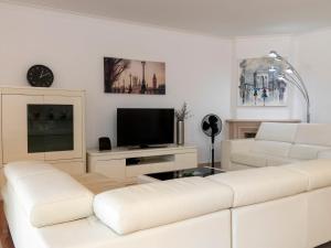 a white living room with two white couches and a tv at Holiday Home Girassol by Interhome in Cascais