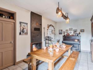 a dining room with a wooden table and a fireplace at Holiday Home Les Roses by Interhome in Yffiniac