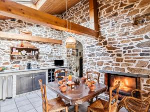 eine Steinküche mit einem Tisch und einem Kamin in der Unterkunft Holiday Home Les Roses by Interhome in Yffiniac