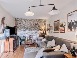 a living room with a stone wall at Holiday Home Les Roses by Interhome in Yffiniac