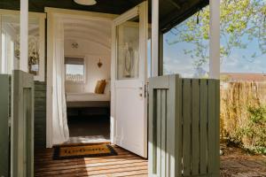 an open door to a bathroom on a house at Little England Retreats - Cottage, Yurt and Shepherd Huts in Othery