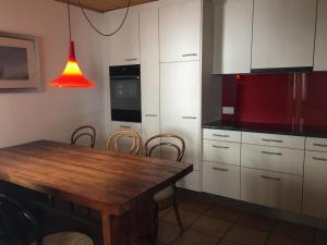 - une cuisine avec une table en bois et des placards blancs dans l'établissement Apartment Forigel UG by Interhome, à Valbella