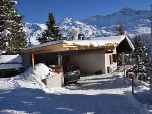 ein Haus mit einem Auto im Schnee in der Unterkunft Apartment Forigel UG by Interhome in Valbella