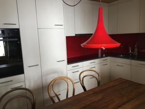 une lumière rouge dans une cuisine avec une table et des chaises dans l'établissement Apartment Forigel UG by Interhome, à Valbella