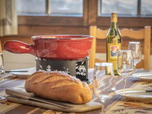 a table with a pot of bread and a bottle of wine at Chalet Le Sorbier by Interhome in Chamoson
