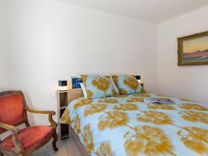 een slaapkamer met een bed en een stoel bij Holiday Home Ericaro by Interhome in Fouesnant