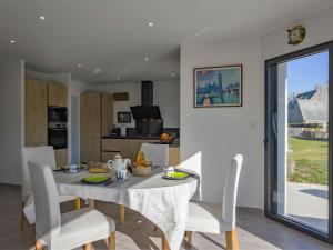 jadalnia i kuchnia ze stołem i krzesłami w obiekcie Holiday Home Ericaro by Interhome w mieście Fouesnant
