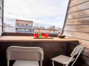 balkon ze stołem i dwoma krzesłami oraz tacą z napojami w obiekcie Studio Les Marinas-14 by Interhome w mieście Deauville