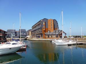 grupa łodzi zakotwiczona w porcie z budynkiem w obiekcie Studio Les Marinas-14 by Interhome w mieście Deauville