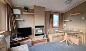 A television and/or entertainment centre at 8 Berth Caravan With Wifi At Seawick Holiday Park Ref 27025r