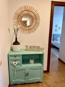 a green cabinet with a mirror on top of it at Villa Yoli, céntrico con plaza de garaje in Avilés