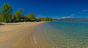 a sandy beach with a group of houses and the water at Villa Riviera in Stavros