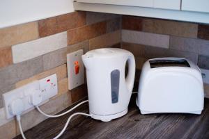 a toaster and toaster on a counter next to an outlet at Mary Jane's Cottage, Lettermacaward in Doochary