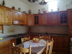 una cocina con armarios de madera y un bol de fruta en una mesa en Villa Panorama, en Lipari
