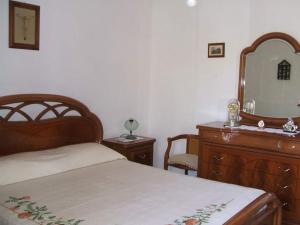 1 dormitorio con cama, tocador y espejo en Villa Panorama, en Lipari