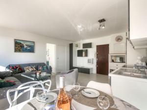 kuchnia i salon ze stołem i krzesłami w obiekcie Apartment Le Méditerranée-3 by Interhome w Fréjus