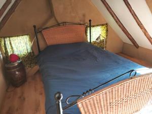 een slaapkamer met een bed op een zolder met 2 ramen bij Vogelvrij in Vierhuizen