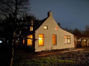 een huis met de lichten aan 's nachts bij Vogelvrij in Vierhuizen