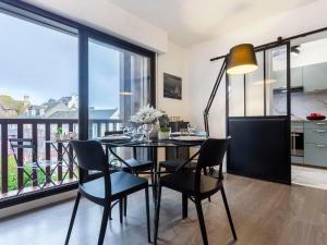 uma sala de jantar com mesa e cadeiras e uma varanda em Apartment Jean Mermoz by Interhome em Deauville