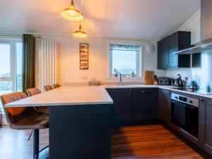 cocina con armarios negros y encimera en Chalet Loch Leven Lodge 25 East by Interhome en Kinross