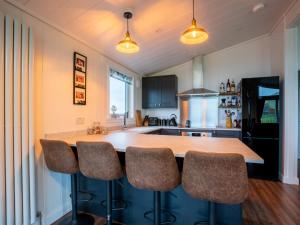 una cocina con una gran isla con taburetes de bar en Chalet Loch Leven Lodge 25 East by Interhome en Kinross