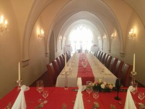 un lungo tavolo in una stanza con un lungo tavolo con tovaglia rossa di Kurhotel Quellenhof a Bad Bertrich