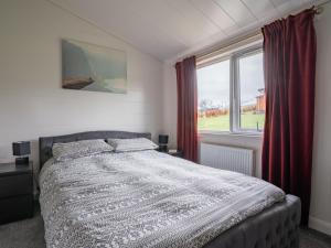 a bedroom with a bed and a large window at Chalet Loch Leven Lodge 25 East by Interhome in Kinross