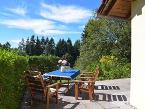 a table and two chairs with a blue table and flowers on it at Holiday Home Konrad by Interhome in Heidersbach