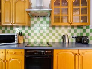 cocina con armarios de madera y lavavajillas negro en Holiday Home Brocks by Interhome, en Drumnadrochit