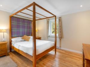 1 dormitorio con cama con dosel y ventana en Holiday Home Brocks by Interhome, en Drumnadrochit