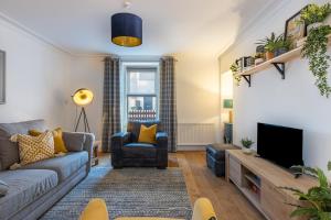a living room with a couch and a tv at Hill Street Haven in Inverness