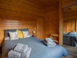 a bedroom with a bed in a wooden cabin at Chalet Loch Leven Lodge 10 by Interhome in Kinross