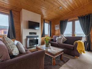 - un salon avec deux canapés et une cheminée dans l'établissement Chalet Loch Leven Lodge 10 by Interhome, à Kinross