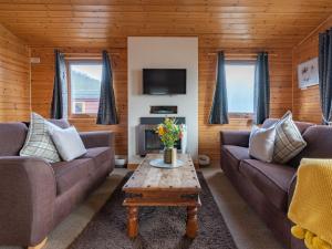 ein Wohnzimmer mit Sofas und einem Couchtisch in der Unterkunft Chalet Loch Leven Lodge 10 by Interhome in Kinross