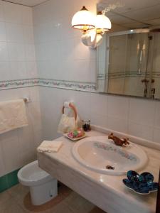 y baño con lavabo, aseo y espejo. en apartamentos en Castellote el batan, en Castellote