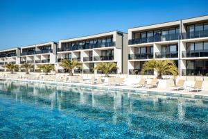 a swimming pool in front of a building at Residence Del Mar Emotion in Pula