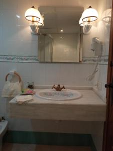 y baño con lavabo y espejo. en apartamentos en Castellote el batan en Castellote