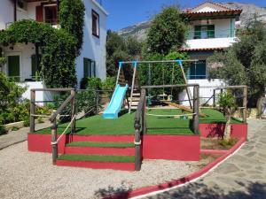 a playground in front of a house with a slide at Sunflowers Apartments in Marathokampos