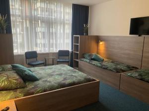 Habitación de hotel con 2 camas y TV de pantalla plana. en Hotel Poseidon en Scheveningen